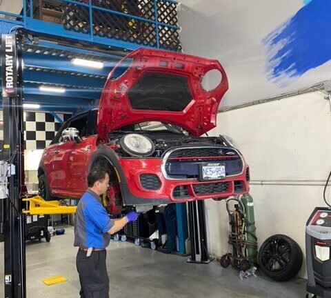 BMW Mini Technician examining a red BMW Mini in the at CG Motorsports